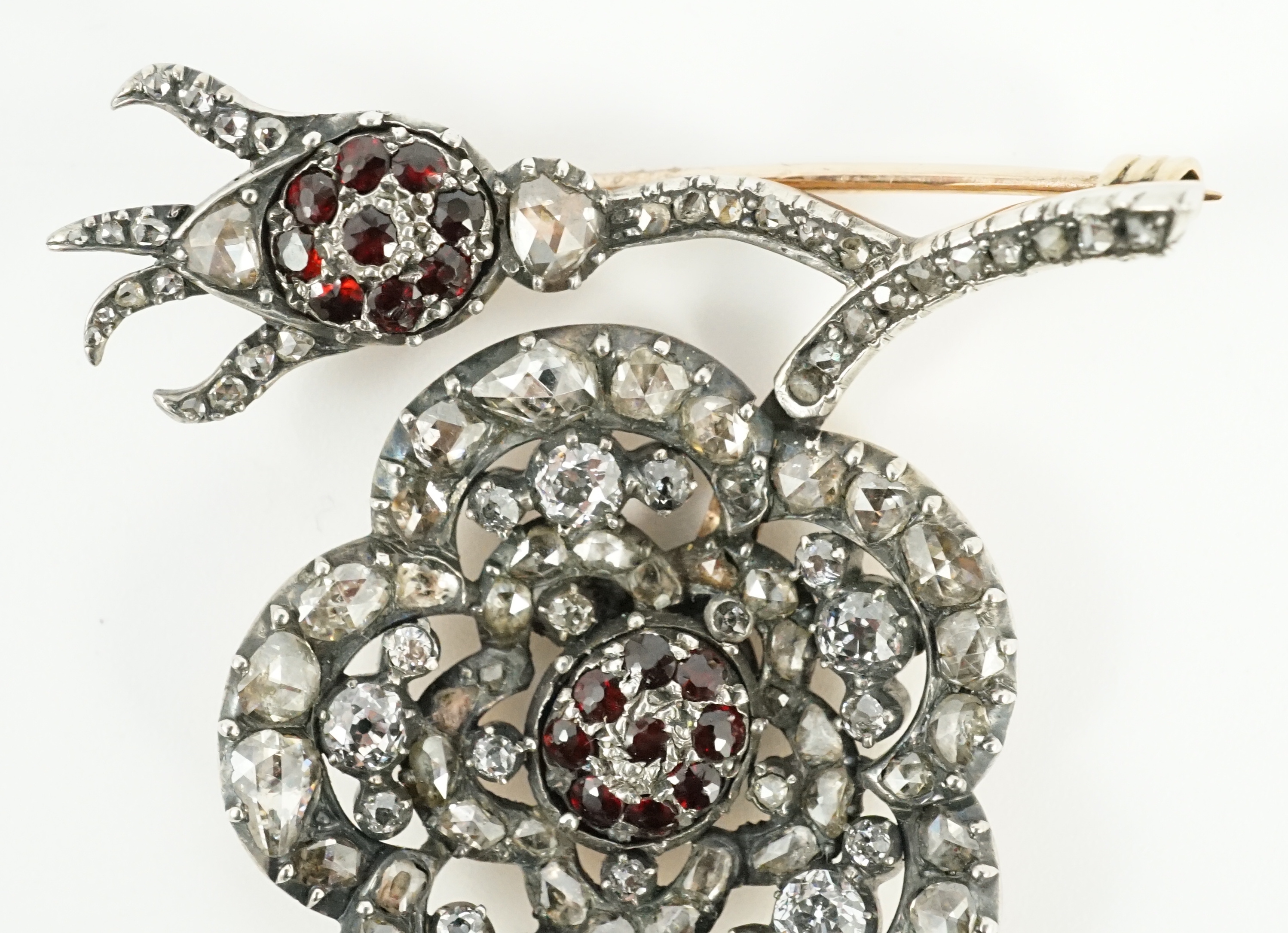 A Victorian, gold and silver, old and rose cut diamond and garnet cluster set pansy brooch